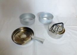 Campingkochgeschirr mit Pfännchen, zwei Töpfen und Wasserkessel.